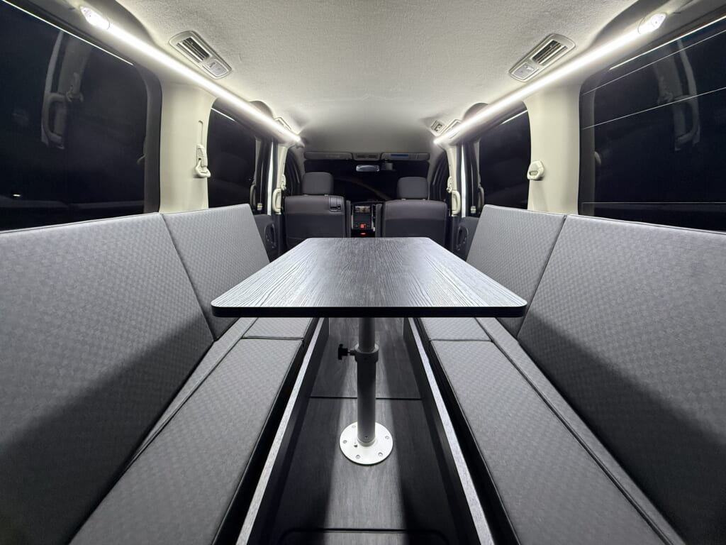 対面ソファーとテーブルを設置したキャンピング架装車の車内(=レイアウト)